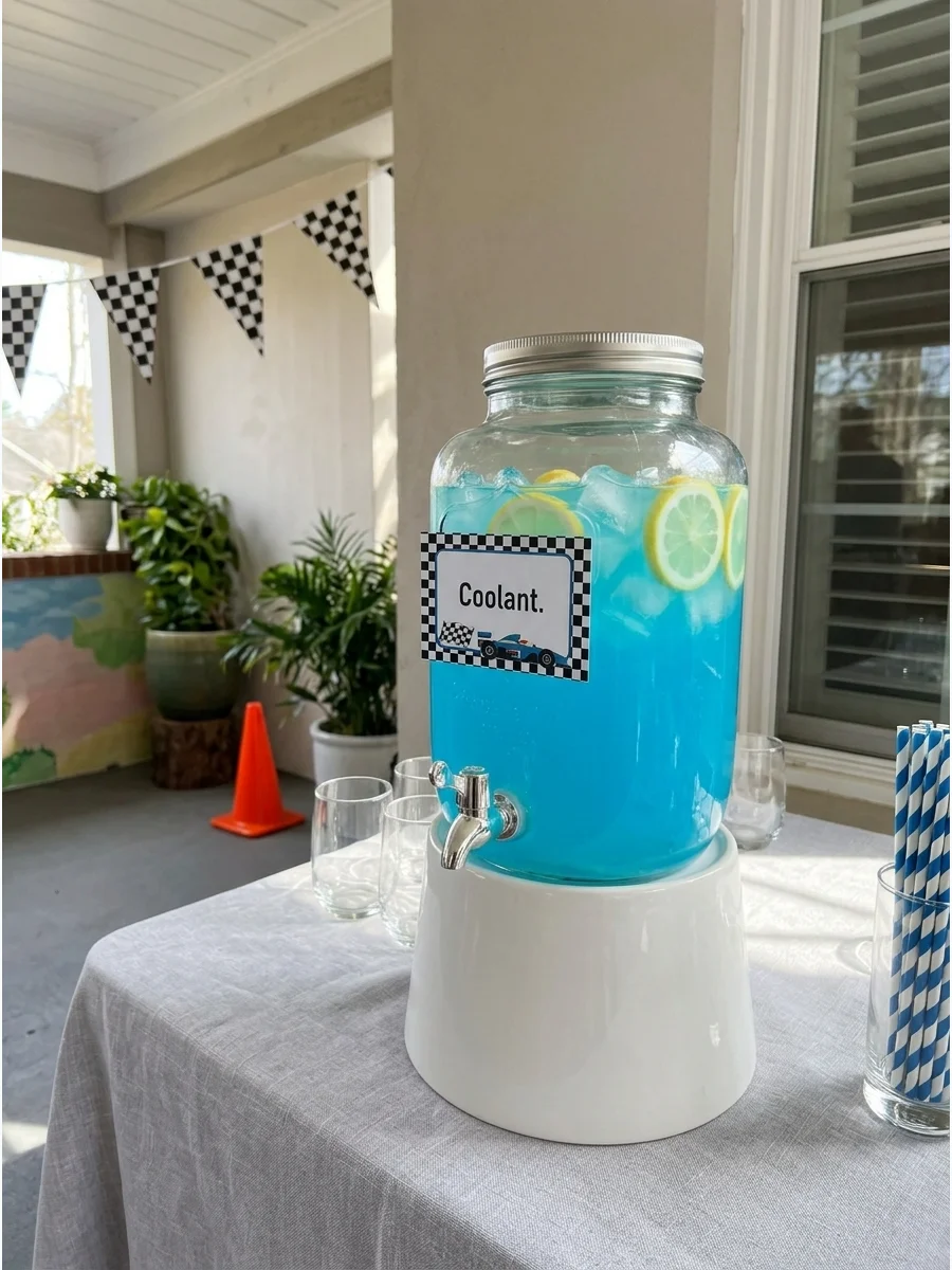 A drink dispenser filled with blue lemonade and lemon slices next to a Coolant sign.