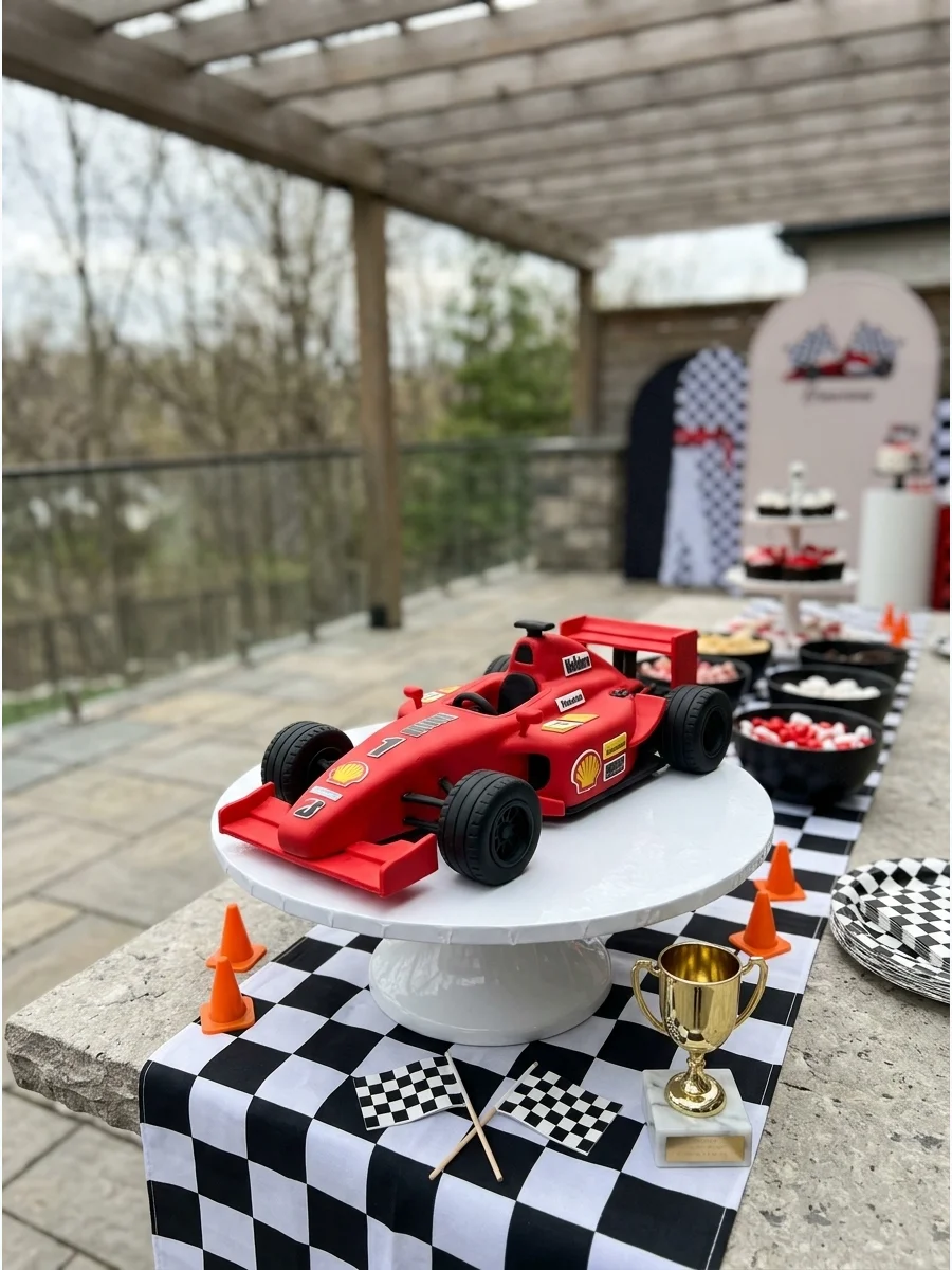 A red cake shaped like a Formula 1 race car with the number one.