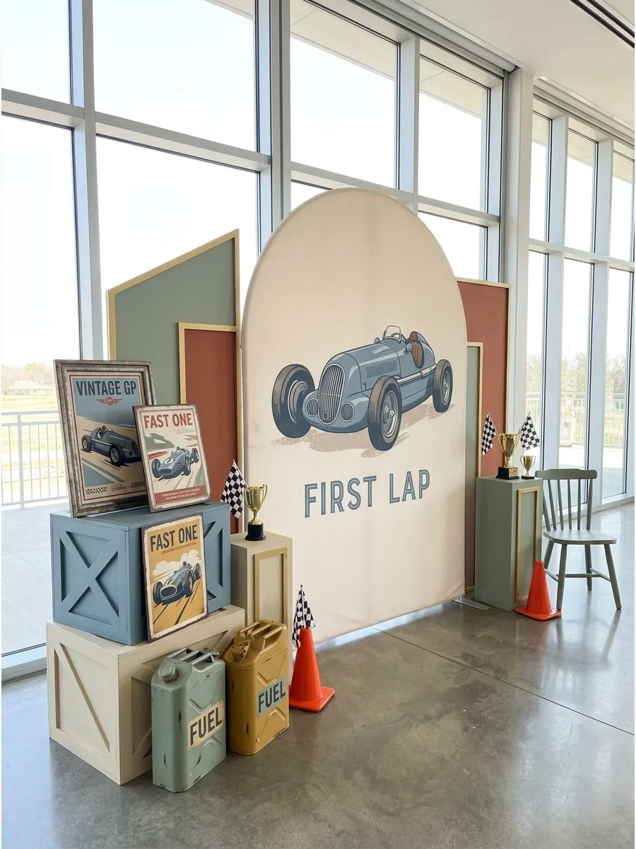 A vintage-style racing backdrop in dusty blue and cream with wooden crate props.