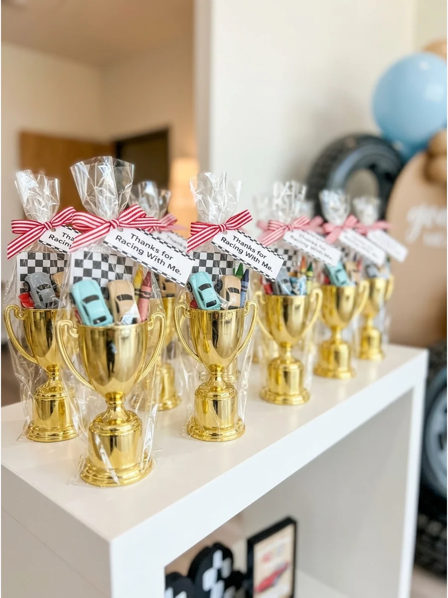Gold plastic trophies used as party favor containers filled with racing-themed toys.
