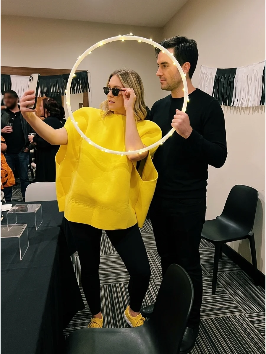 A couple dressed as a social media influencer and a glowing ring light.