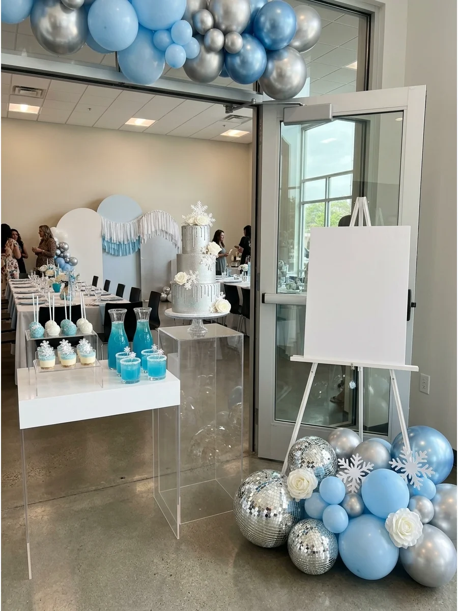 A modern baby shower setup with disco balls and light blue balloons.