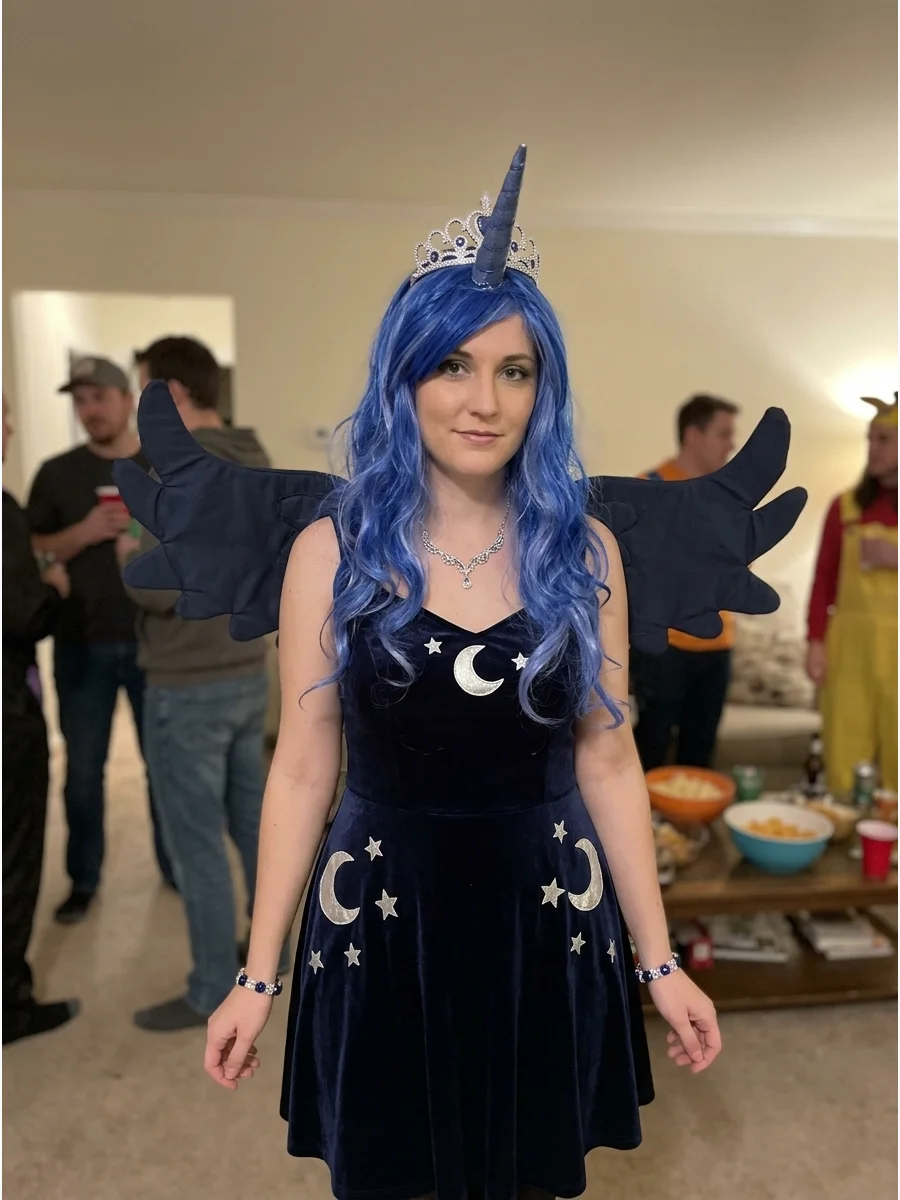 Princess Luna Costume. Wear a dark navy or midnight-blue dress decorated with moons and stars. Complete the Princess Luna look with dark wings, a horn, silver jewelry, a crown, and