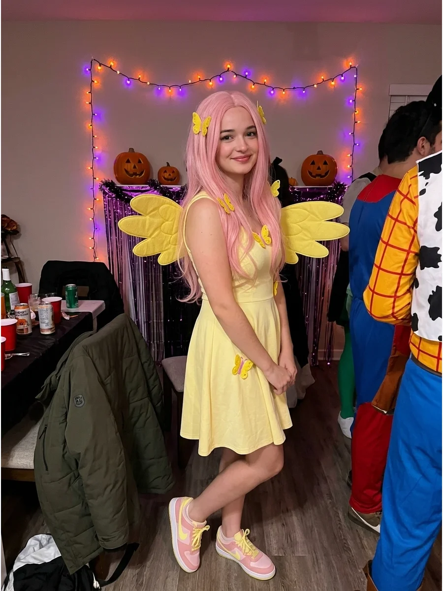 Fluttershy Costume. Choose a soft yellow dress or matching yellow separates for a gentle Fluttershy costume. Complete the outfit with a long pink wig, yellow wings, butterfly detai