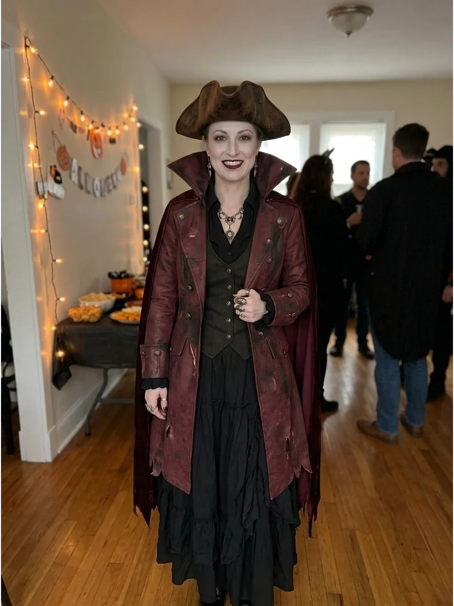 Vampire Pirate Costume. Layer a burgundy pirate coat over a black blouse, waistcoat, and long skirt. Add pale makeup, dark lipstick, ornate jewelry, and a dramatic high-collared ca