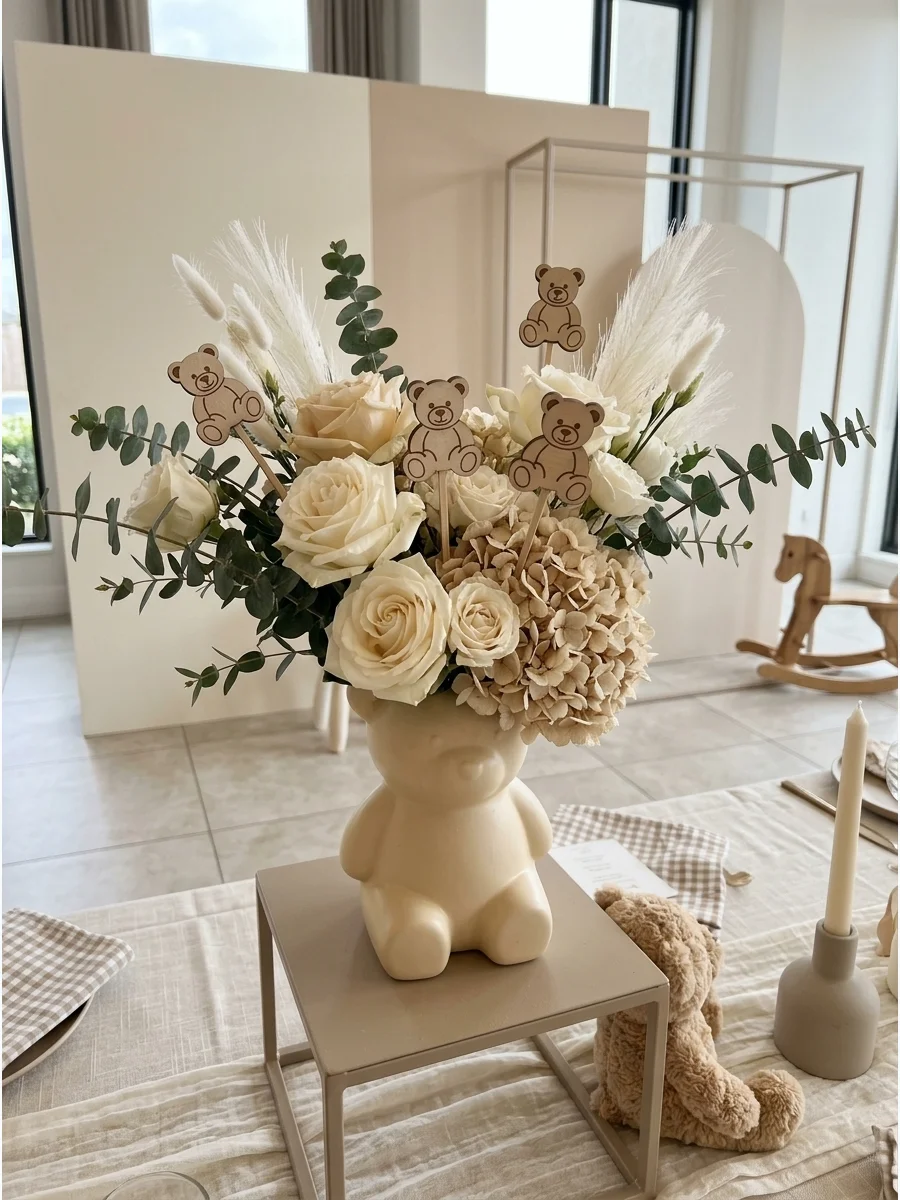 A floral arrangement in a white vase with a wooden bear pick.