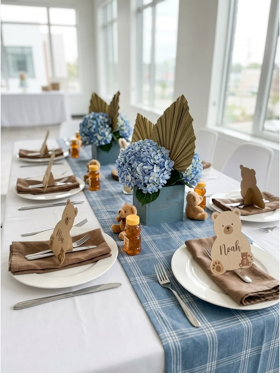A baby shower table with blue plaid runners and brown napkins.