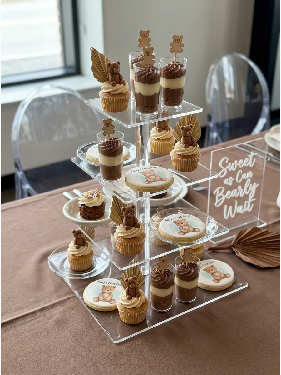 A modern baby shower table with acrylic chairs and neutral linens.