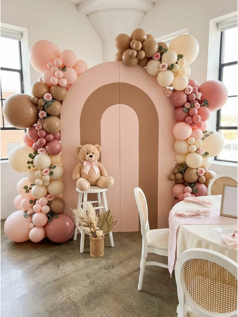 A pink and mocha balloon display with a teddy bear for a baby girl shower.