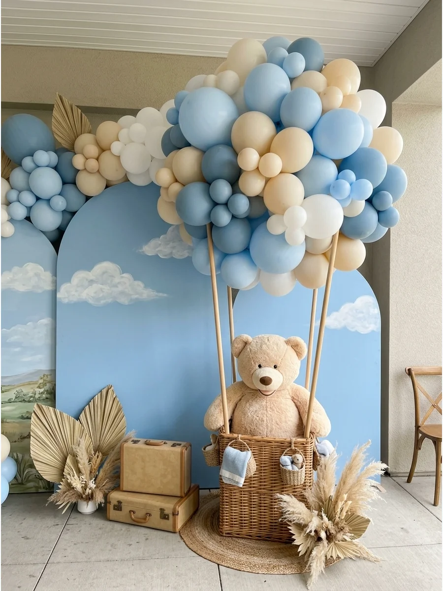 A teddy bear sitting in a hot-air balloon basket made of balloons and wicker.