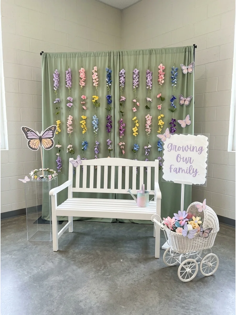 A floral photo booth backdrop with hanging flower garlands and a garden bench.