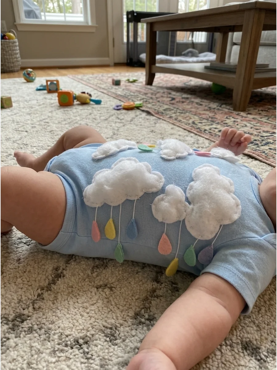 Little Cloud Costume. Dress the baby in pale blue or white and attach soft cotton-like fabric shapes to the front of the outfit. Add felt raindrops in pastel colors for a sweet wea