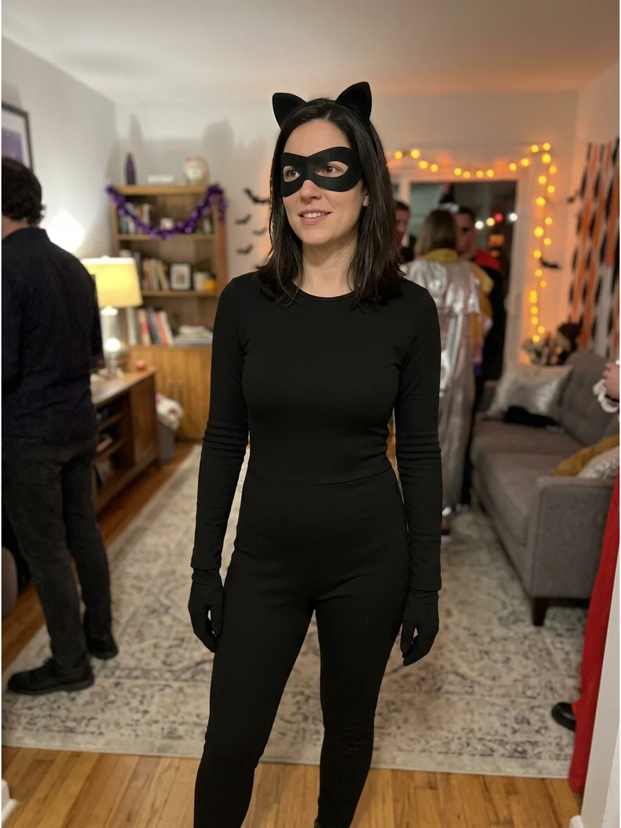 Minimalist Catwoman Costume. Combine a plain black jumpsuit with a small cat-ear headband and black eye mask. Keeping the accessories simple creates a fashionable costume that rema