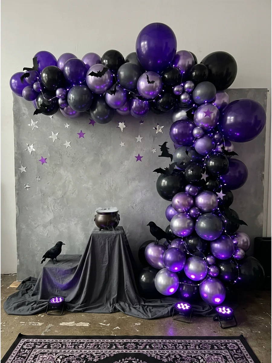 A moody purple and black balloon display with silver stars in a studio space.