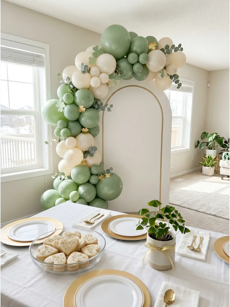 Sage green baby shower decor with clover accents in a bright living room.