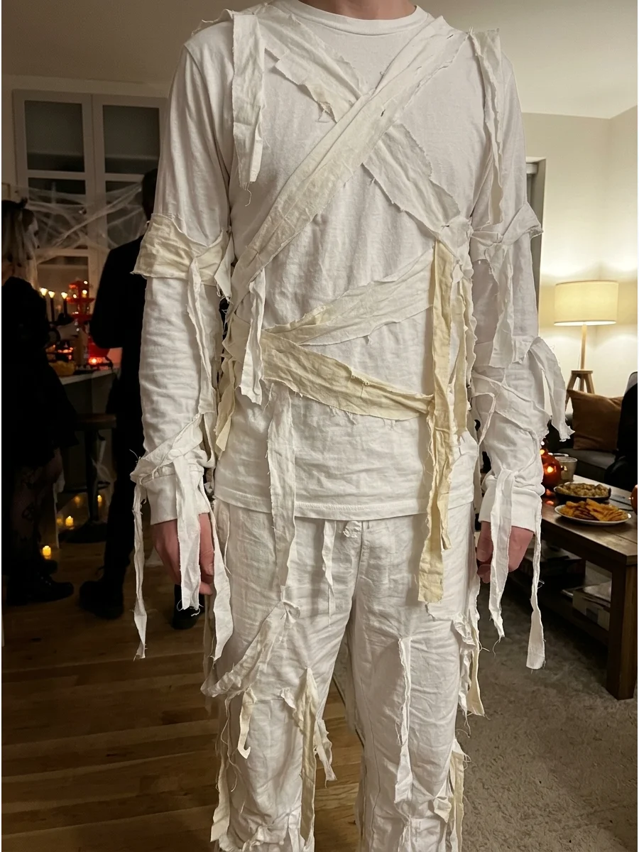 Classic DIY Mummy Costume. Start with a white long-sleeve shirt and matching pants, then attach torn strips of an old white sheet across the clothing. Leave several short ends hang