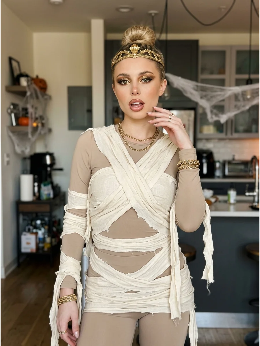 Glamorous Mummy Costume. Combine a fitted neutral outfit with carefully draped cream fabric and gold accessories. Add metallic eye makeup and a decorative headpiece for a glamorous