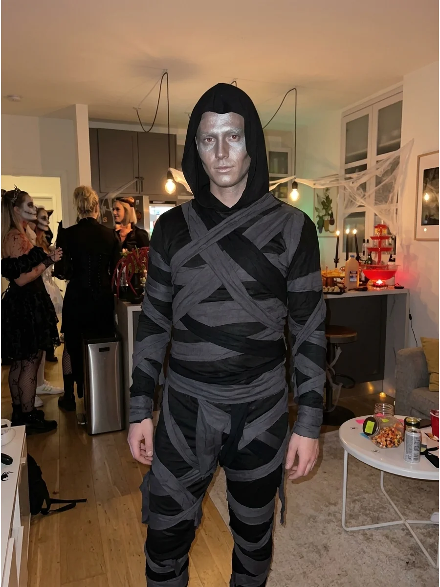 Shadow Mummy Costume. Create the costume with charcoal, black, and dark gray strips instead of traditional cream fabric. Add a black hood and subtle silver makeup for a mysterious