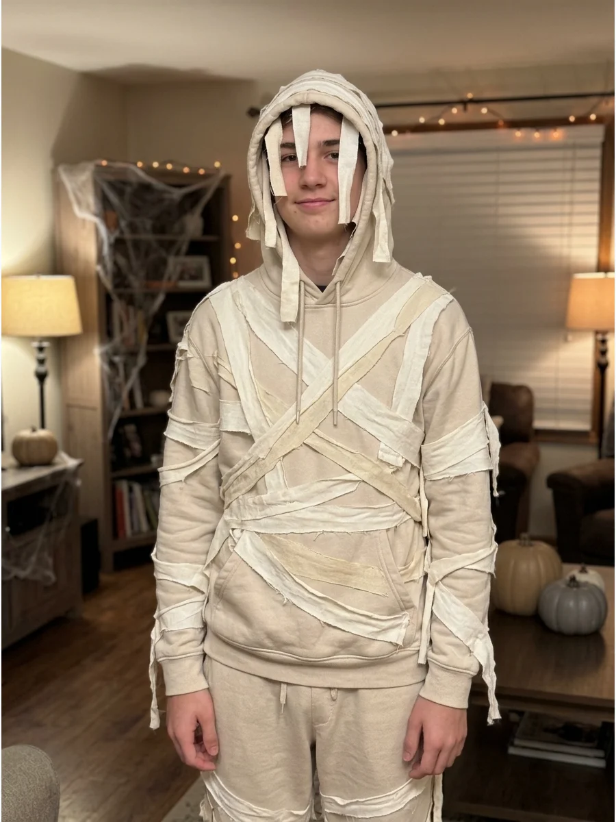 Hoodie Mummy Costume. Attach fabric strips to a white, beige, or gray hoodie and matching sweatpants. Add several short pieces around the hood to frame the face without covering th