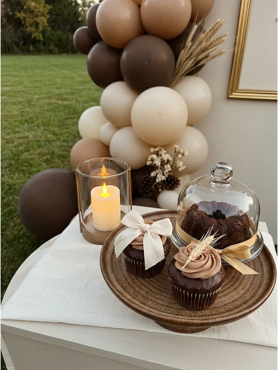 A brown and cream balloon display with chocolate treats.