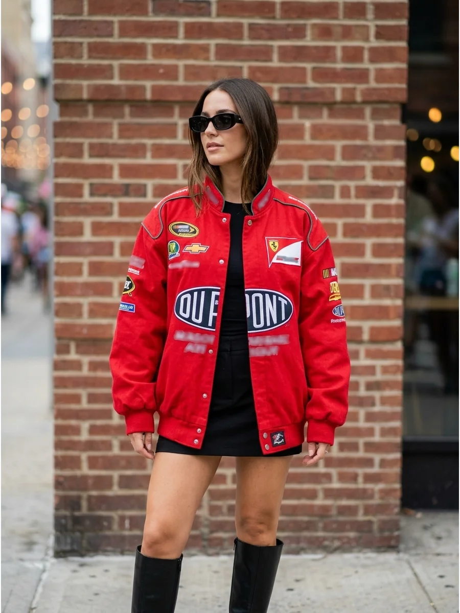Woman wearing an oversized red racing jacket with black boots.