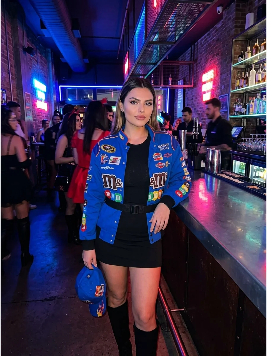 Woman in a blue racing jacket and black mini skirt at a bar.