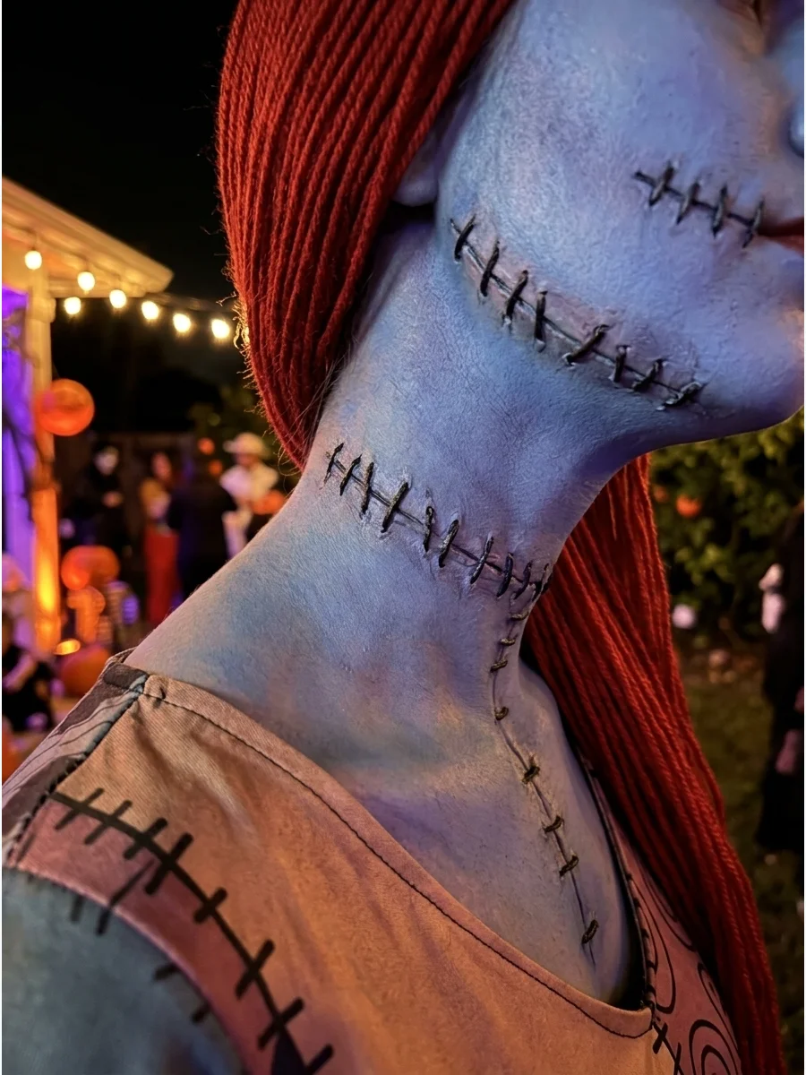 Textured 3D makeup stitches on a blue neck and jawline.