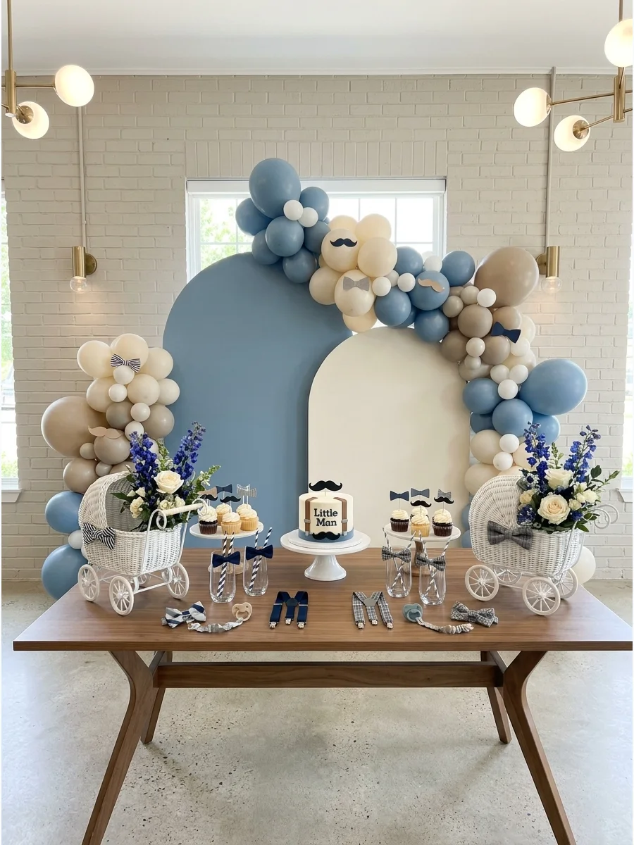 A dusty blue and cream balloon garland decorated with paper bow ties for twin boys.