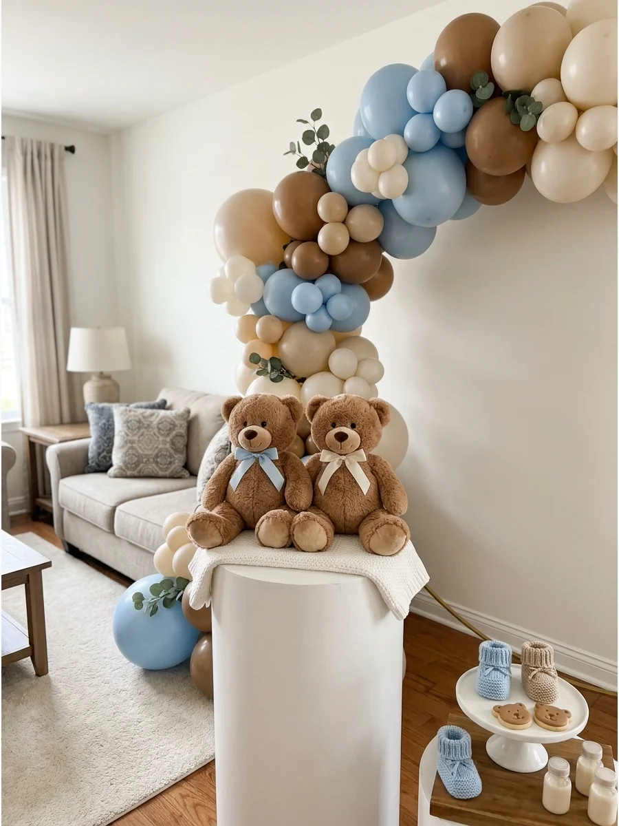 Two matching teddy bears on a white pedestal surrounded by beige and terracotta balloons.