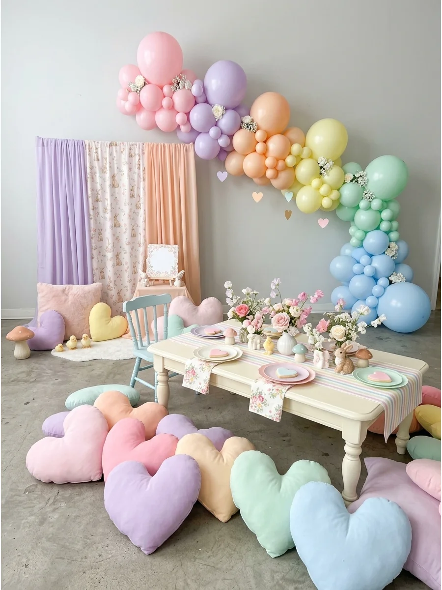Pastel heart pillows on a light wood floor in a photography studio.