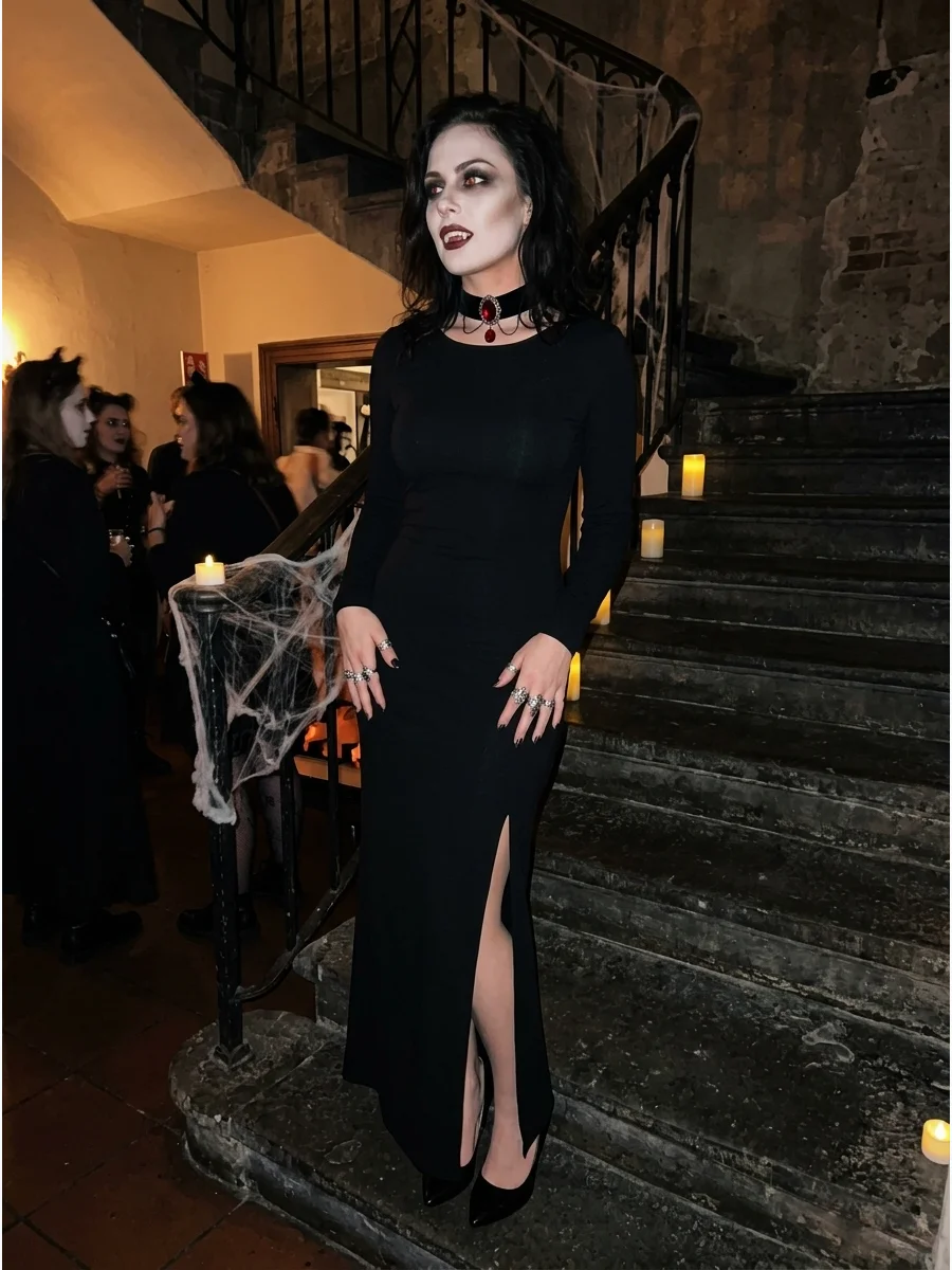 Elegant woman in a black dress with vampire makeup on a staircase.