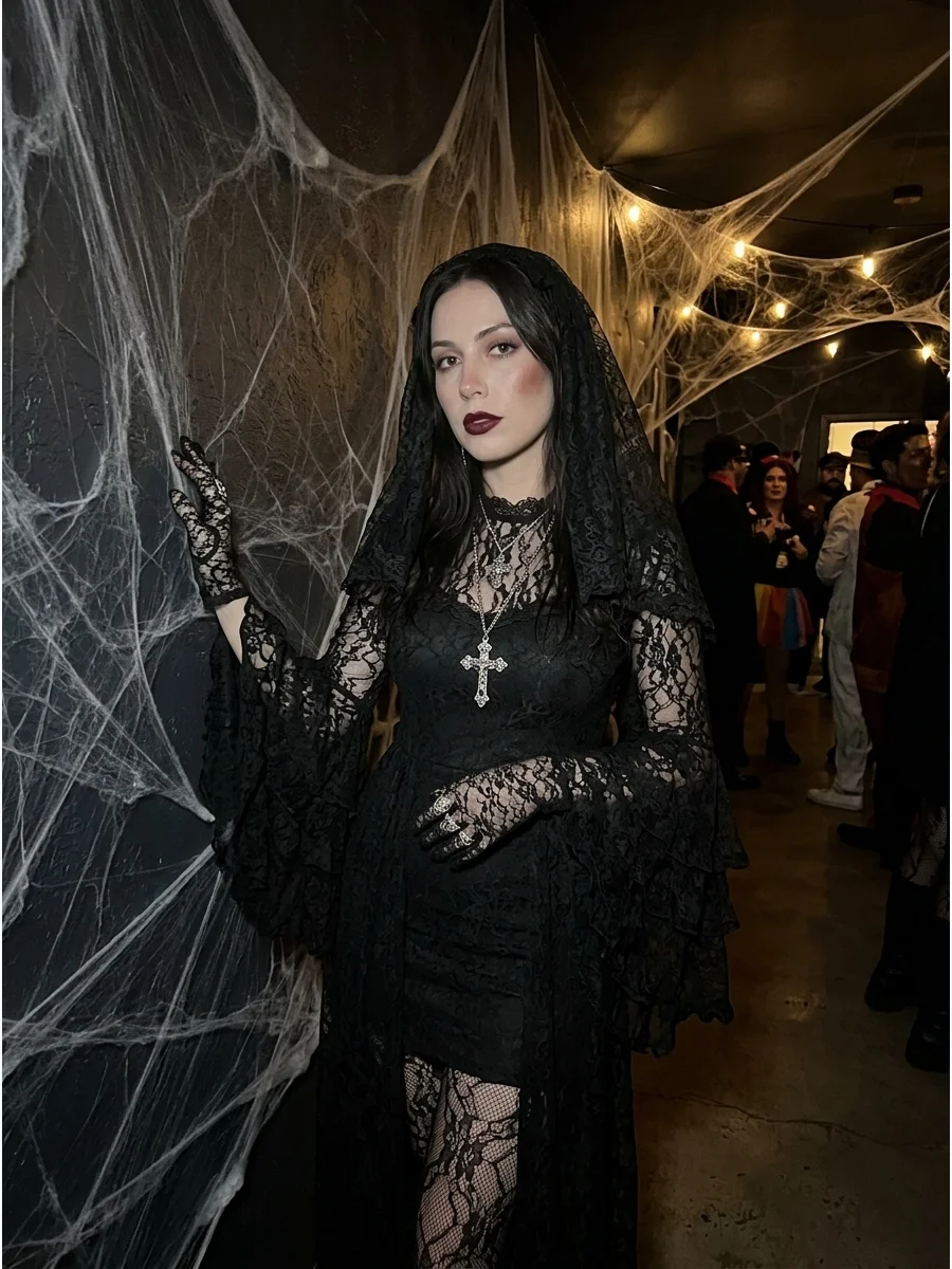 Woman in a layered black lace vampire costume with silver jewelry.