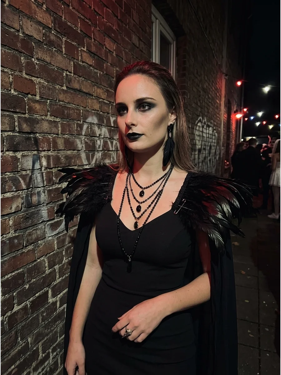 Raven inspired vampire costume with feathered shoulders and dark makeup.