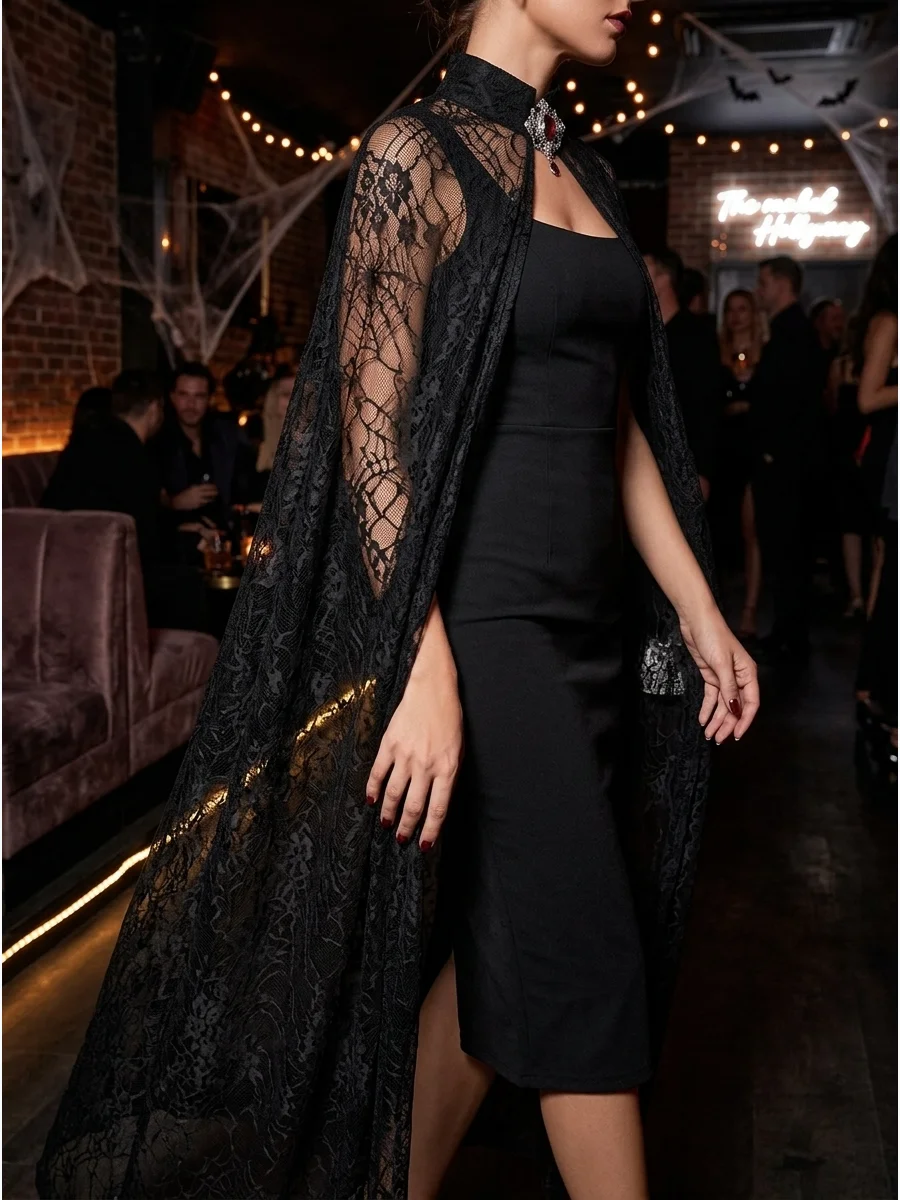 Woman in a black lace cape vampire costume in a dark lounge.
