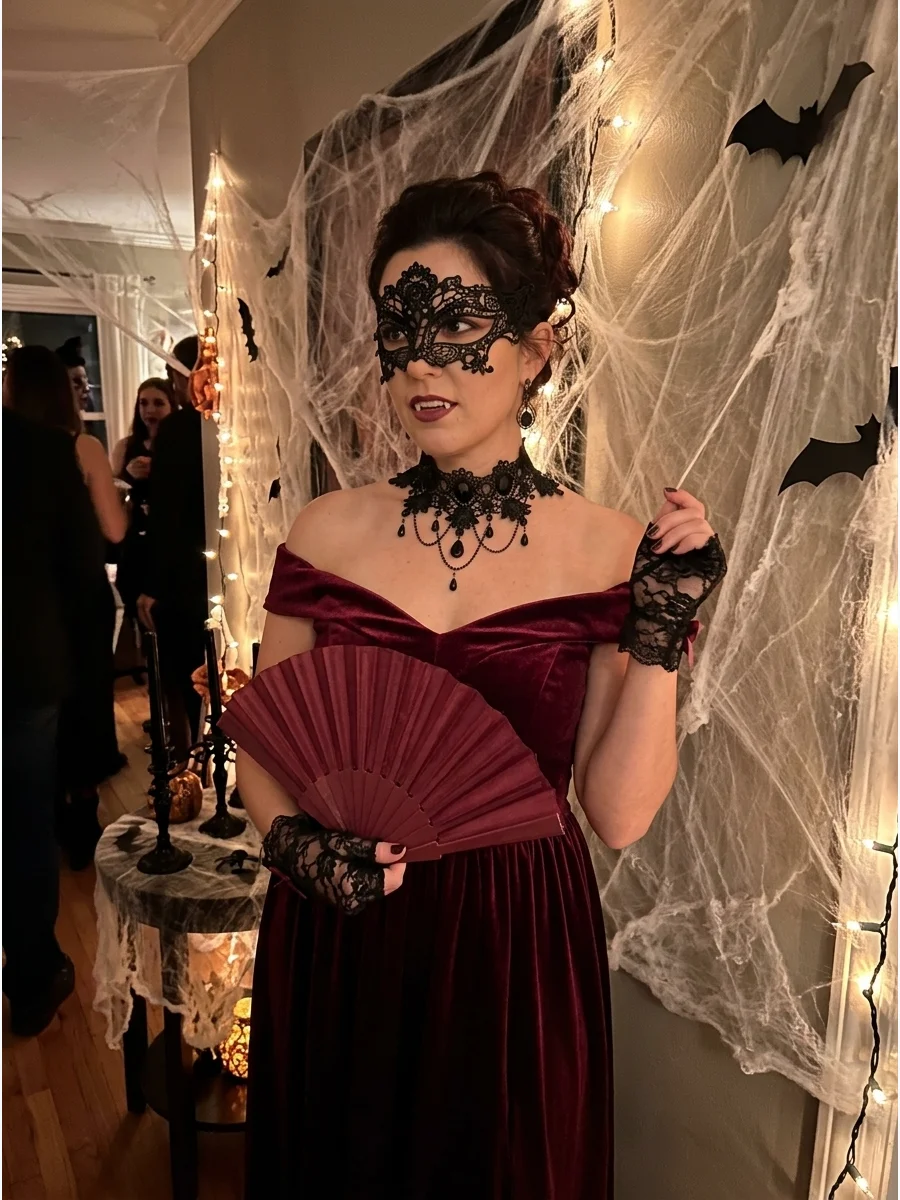 Woman in a burgundy dress and ornate mask in a decorated party space.