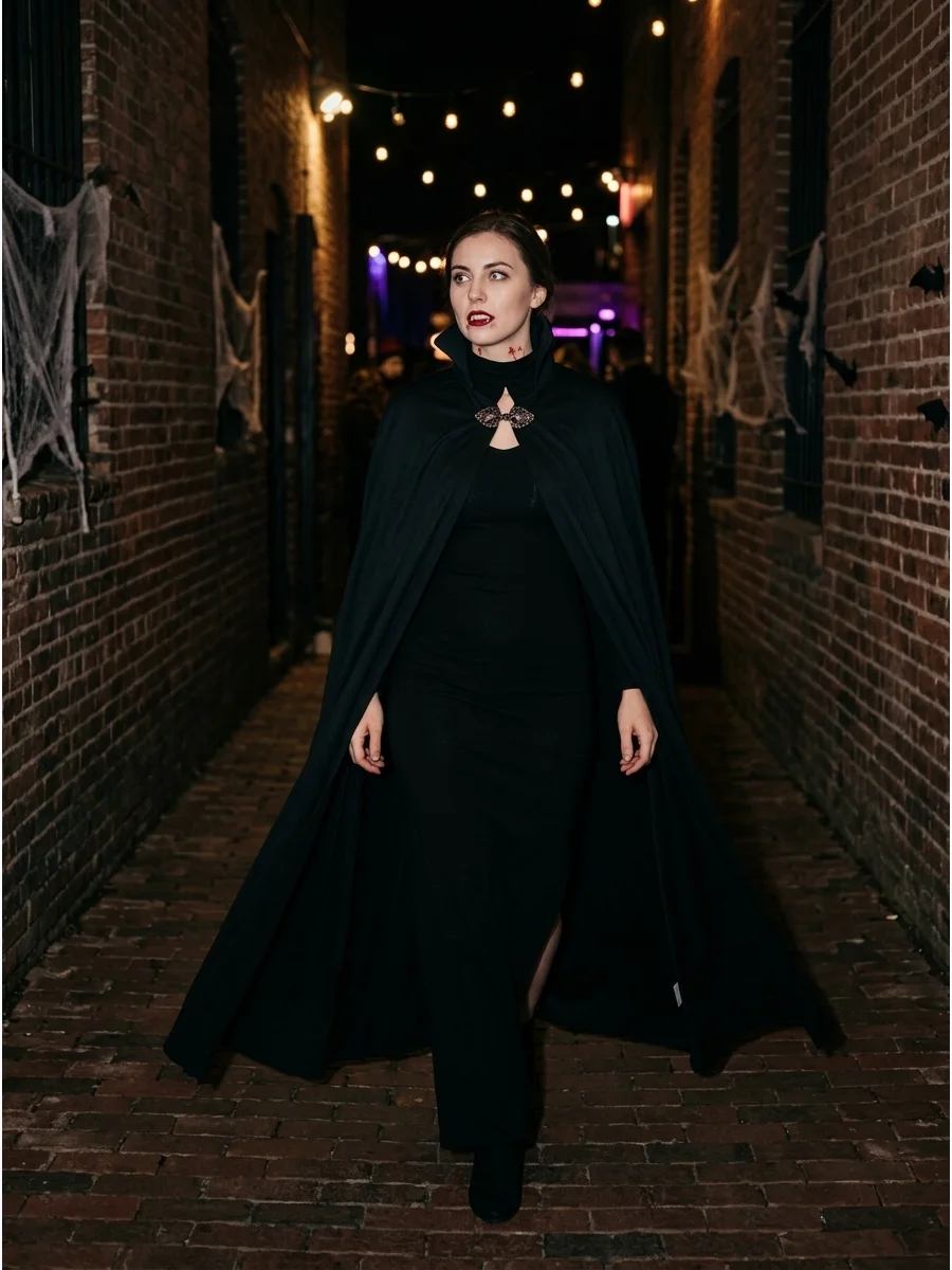 Dramatic black cape vampire costume in a dark alley.