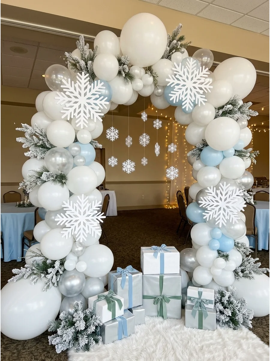 A white and silver balloon arch decorated with snowflakes.
