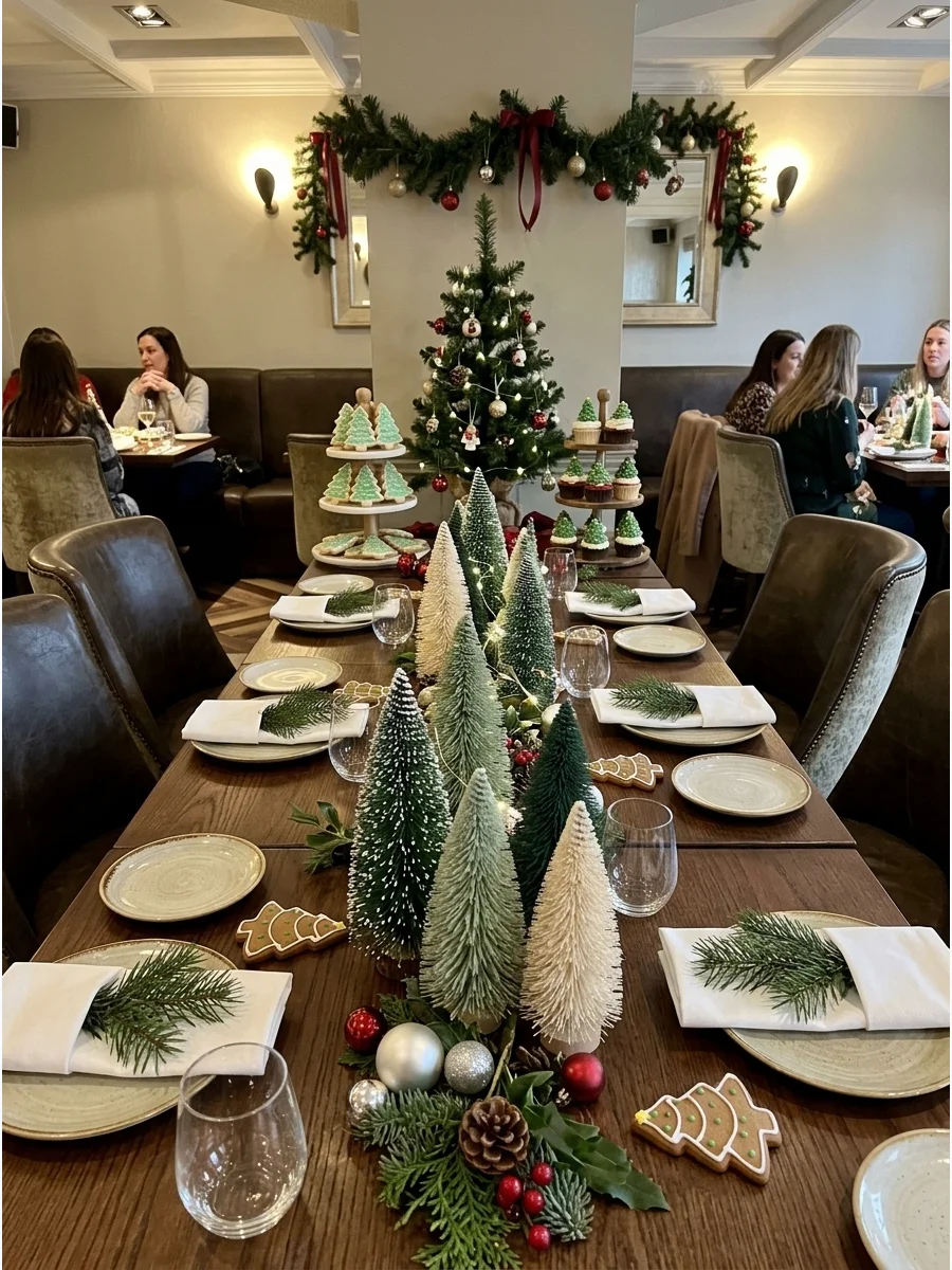 A baby shower table decorated with many miniature Christmas trees.