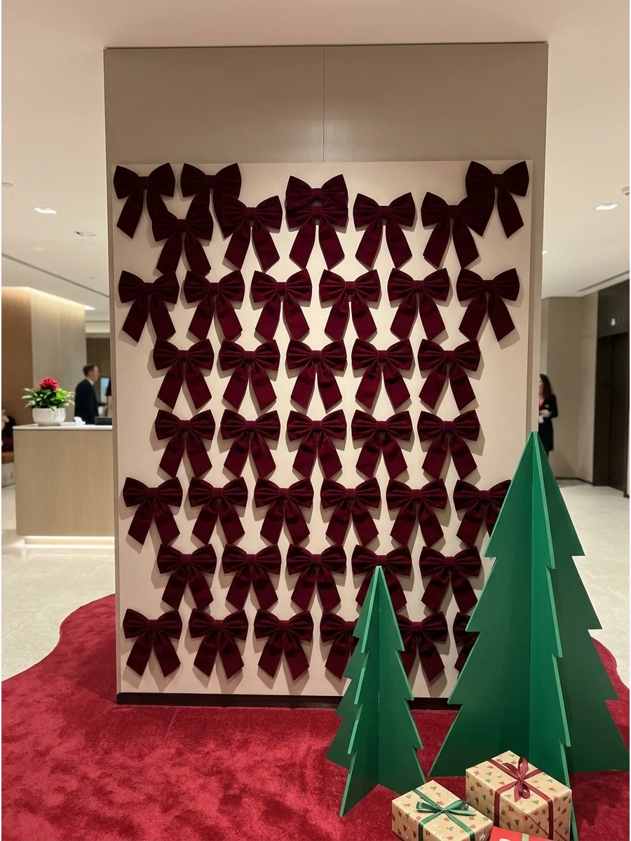 An elegant wall backdrop covered in rows of burgundy velvet bows.