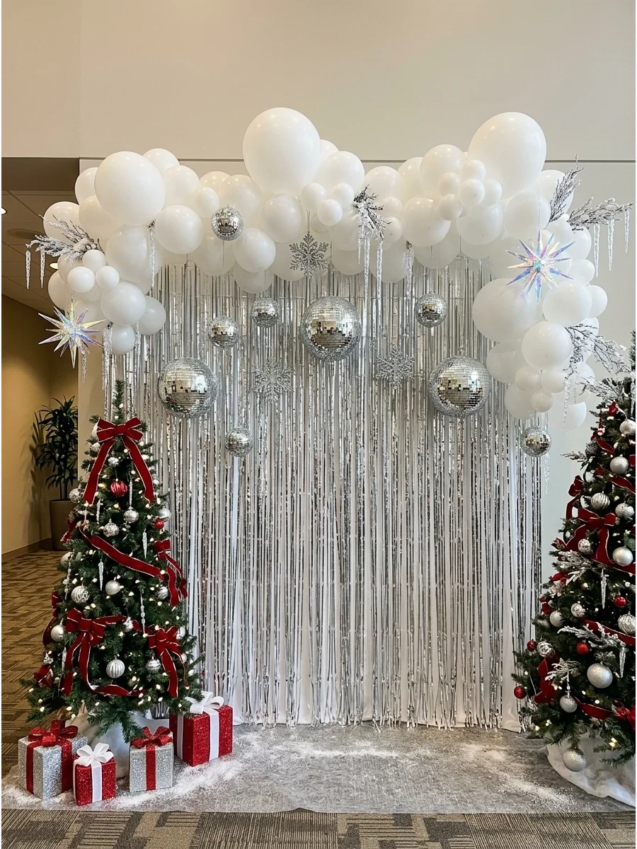 A silver fringe backdrop with white balloons and mirrored ornaments in an office lobby.