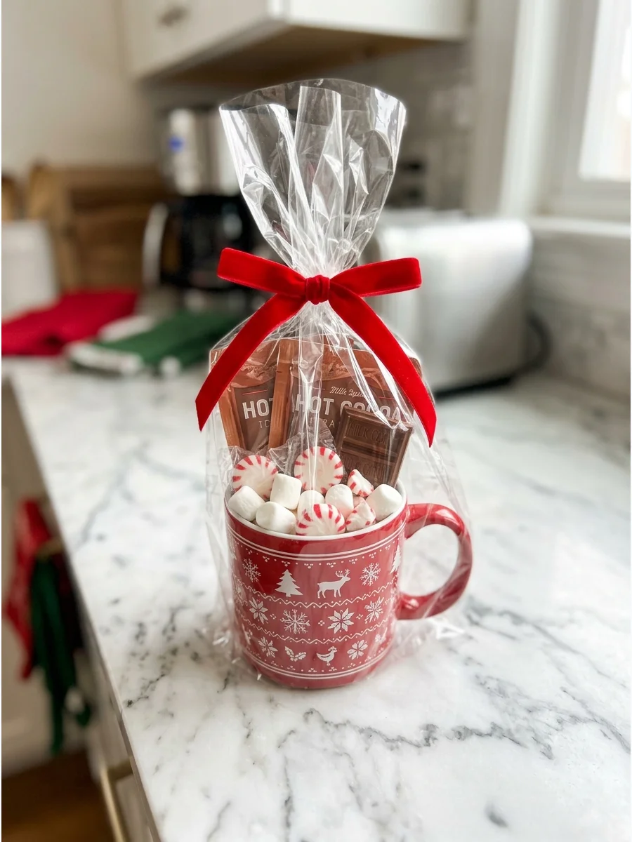 A festive red mug filled with hot cocoa supplies on a kitchen counter.