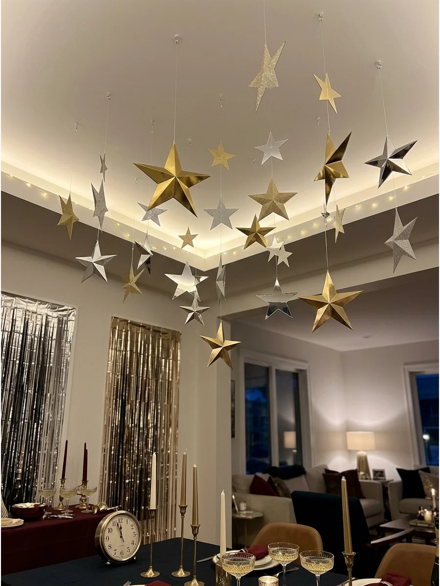 Gold and silver stars hanging from a ceiling at various heights.