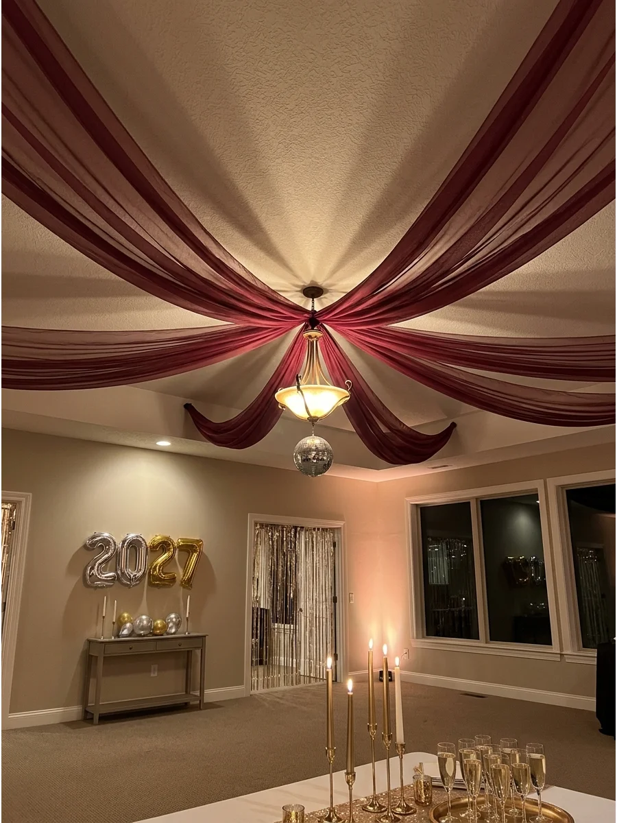 Dramatic burgundy fabric draped across a ceiling for a festive look.