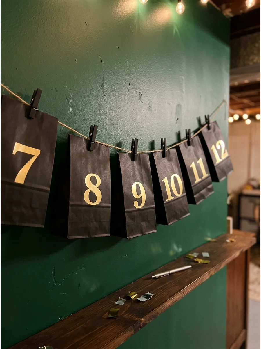 Numbered countdown bags hanging on a wall.