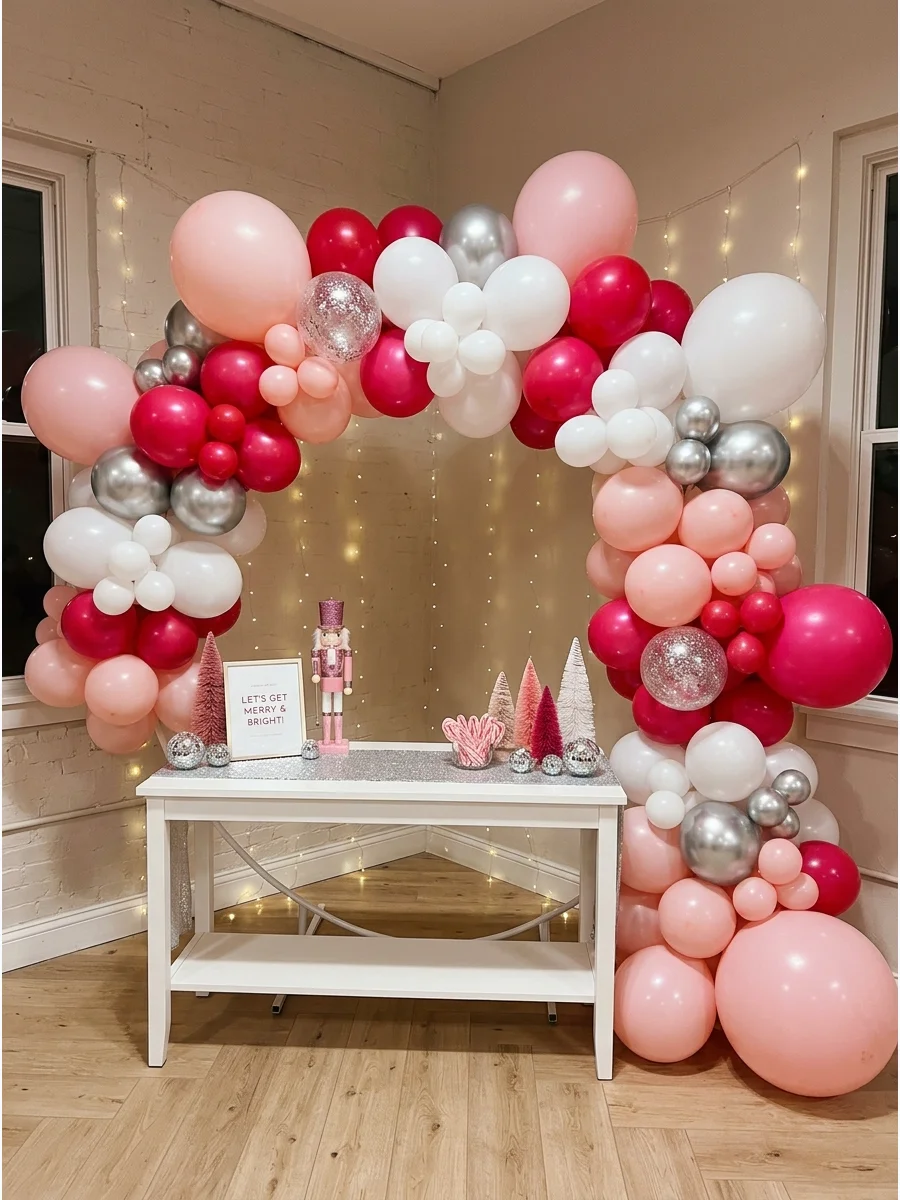 A large balloon arch with various shades of pink and metallic silver.