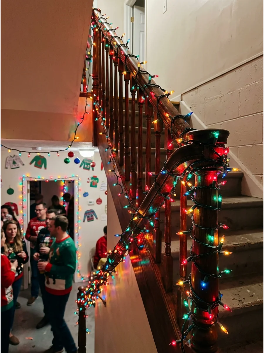 Colorful Christmas lights wrapped around a basement staircase banister.