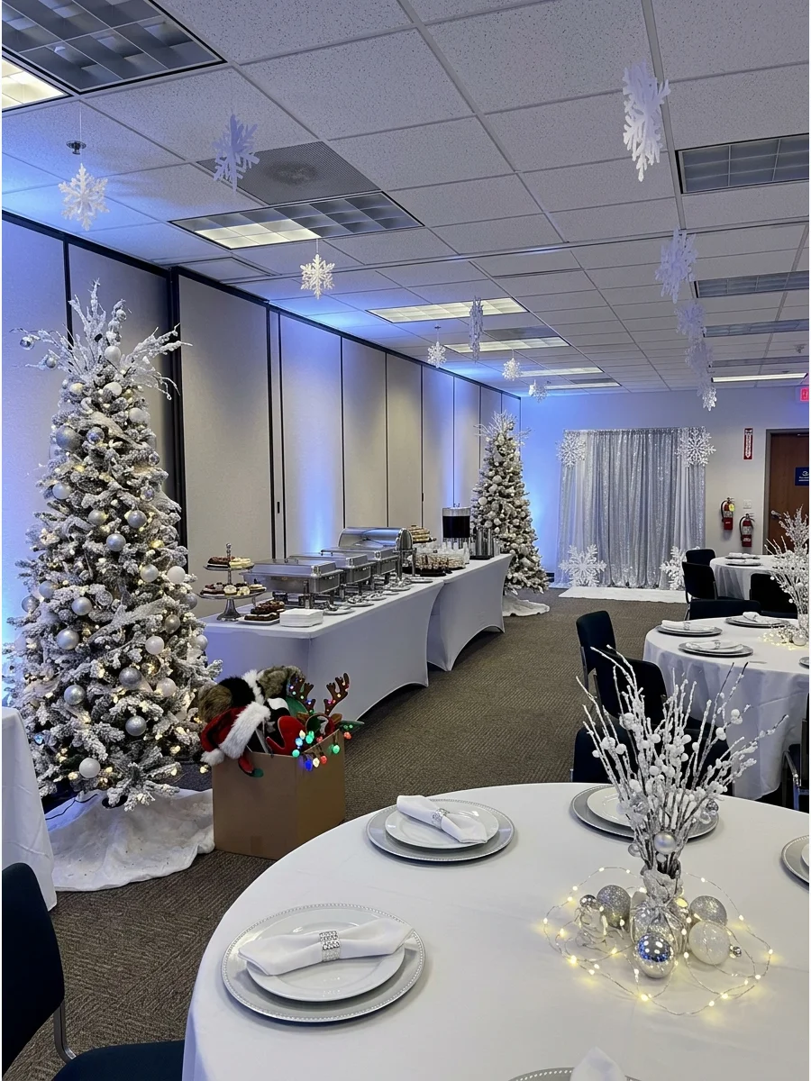 A large conference hall decorated with white trees, silver accents, and blue lights.