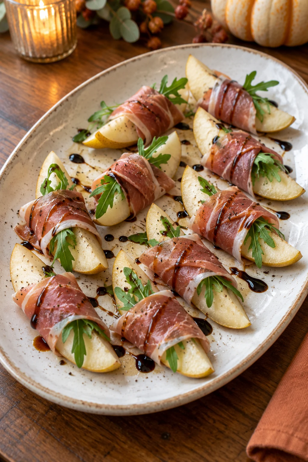 Fresh pear wedges wrapped in prosciutto with arugula and balsamic glaze
